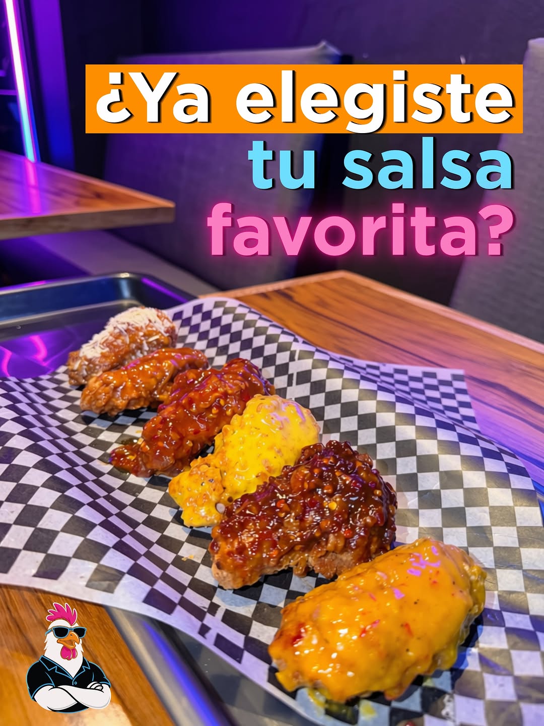 Alitas Wingwood bañadas en diferentes salsas, sobre papel a cuadros